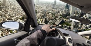 A person is driving a car in a surreal scene, steering over a cityscape from a high angle, conveying thrill and adventure. The city is filled with tall buildings.