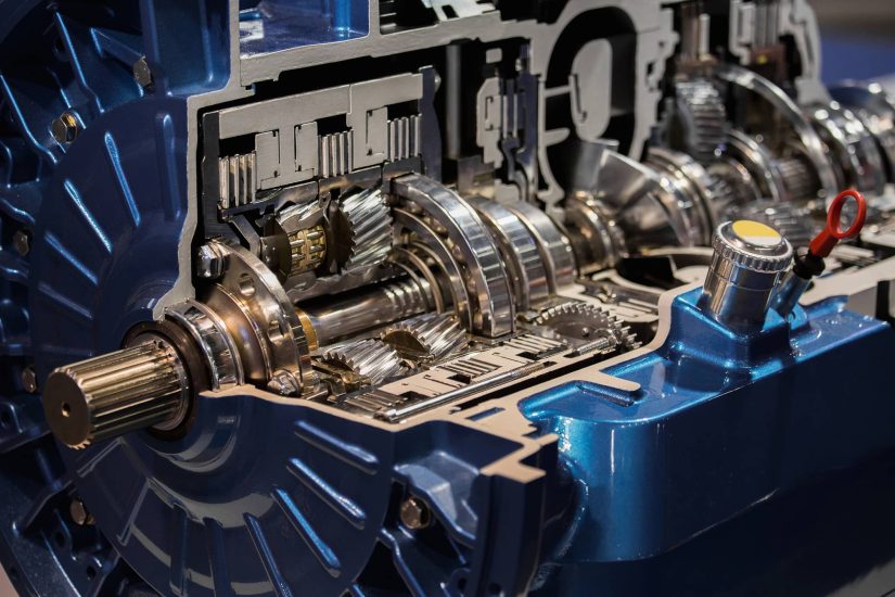 Close-up of a metallic blue automotive transmission cutaway, showcasing intricate gears and mechanical components, highlighting engineering precision.