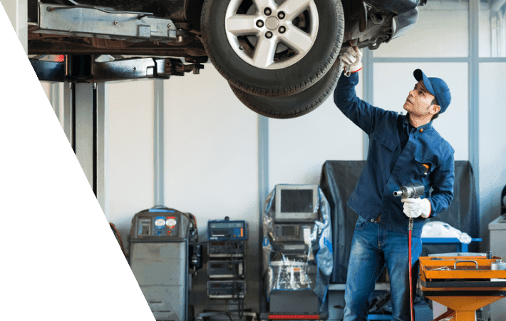 mechanic checking an elevated car in repair shop