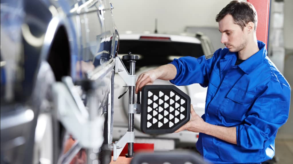 img - auto-mechanic-at-wheel-alignment-work-with-sensor